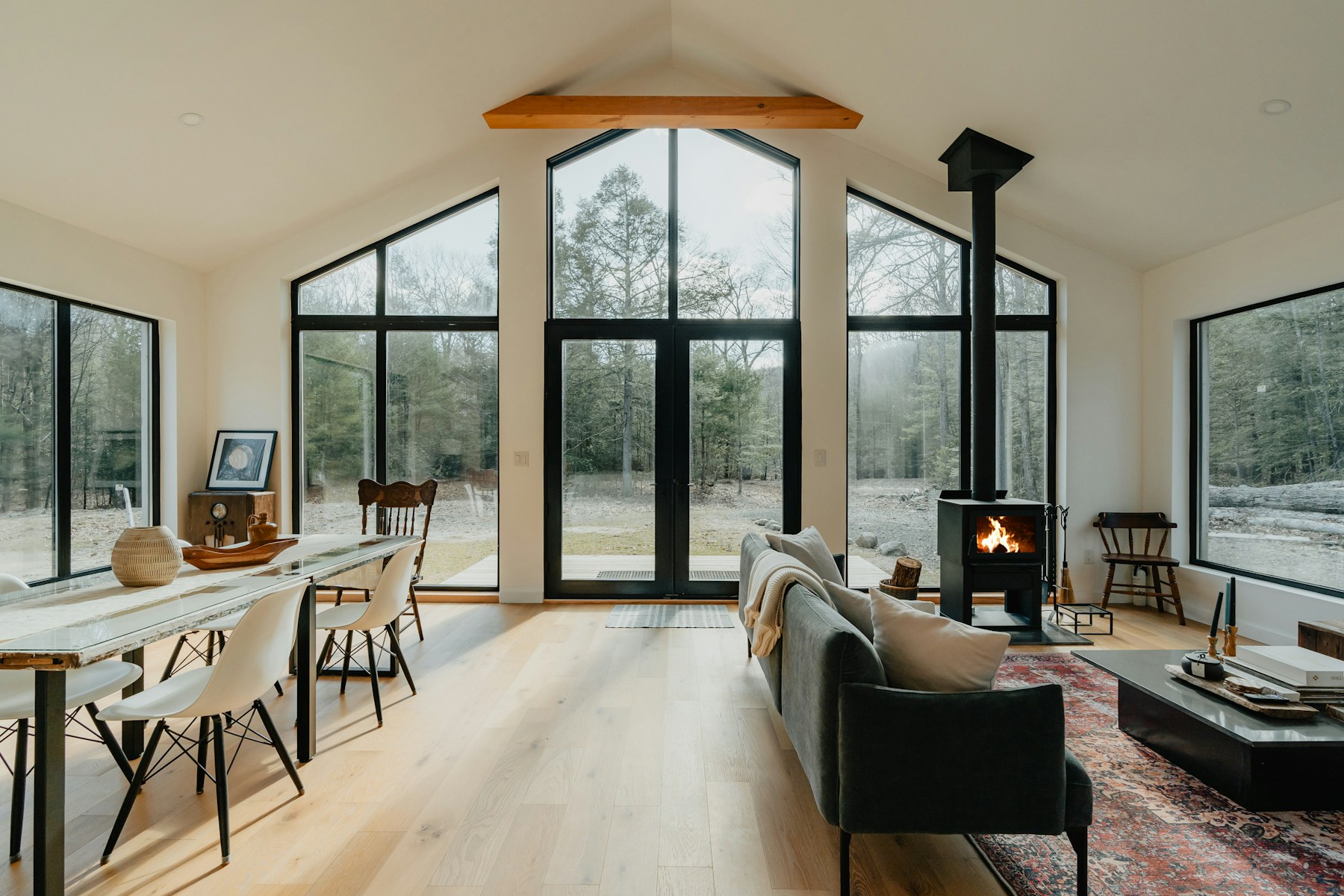 Photographed living room with large forest-facing windows