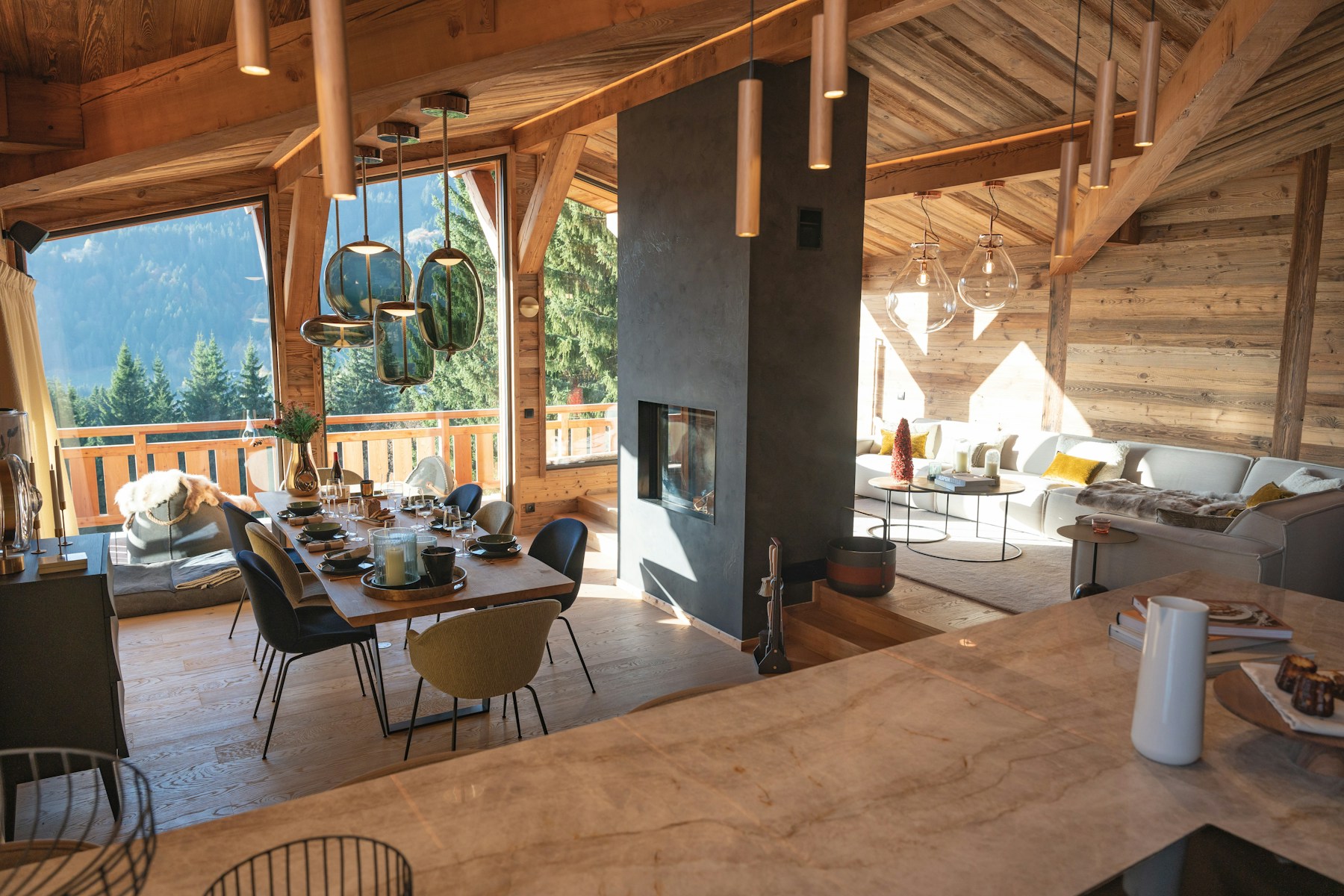 Sunlit wood-lined mountain chalet with an open living area and forest views