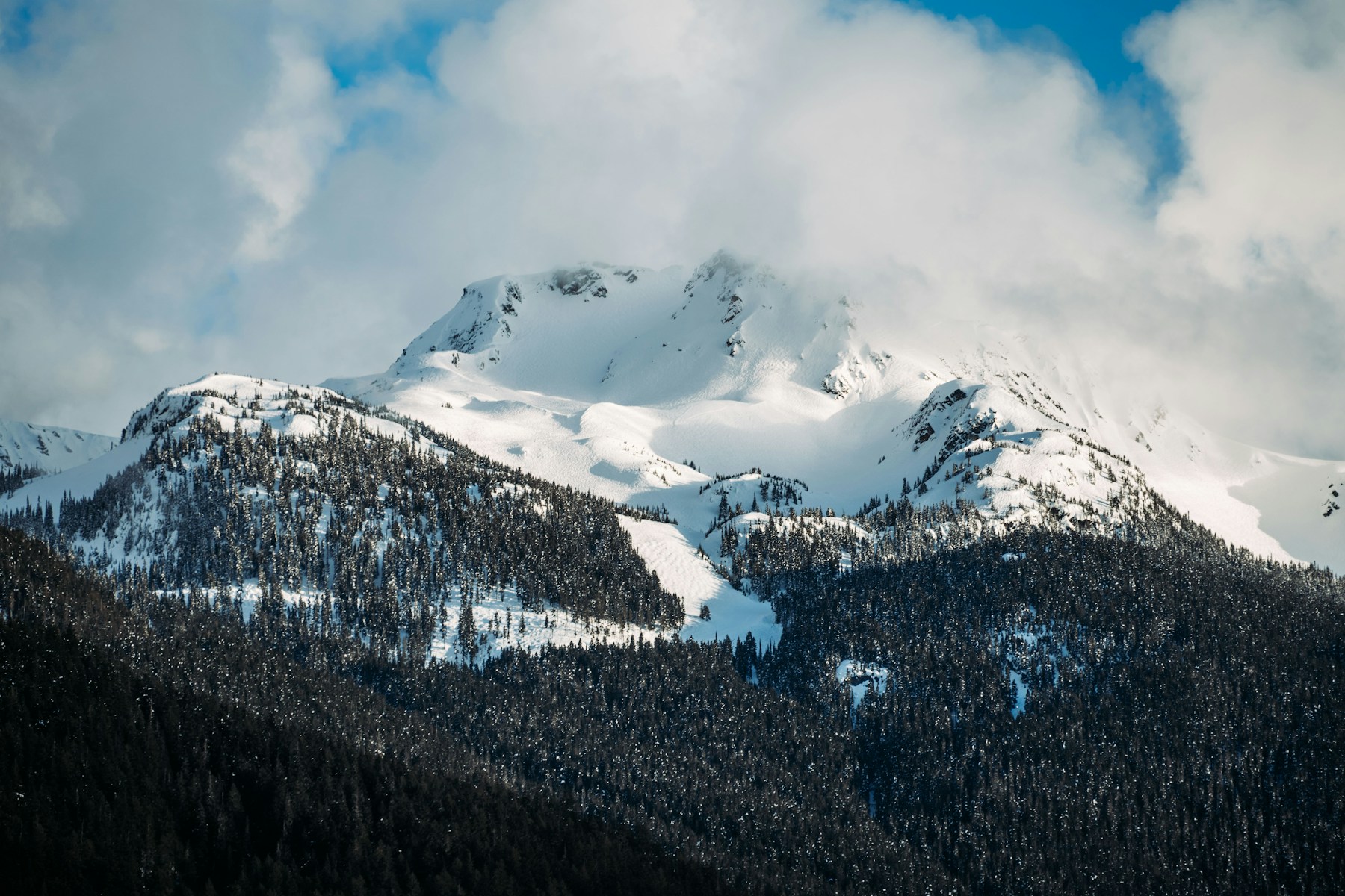 Sunlight and blue-grey shade across snowy mountain slopes in Whistler